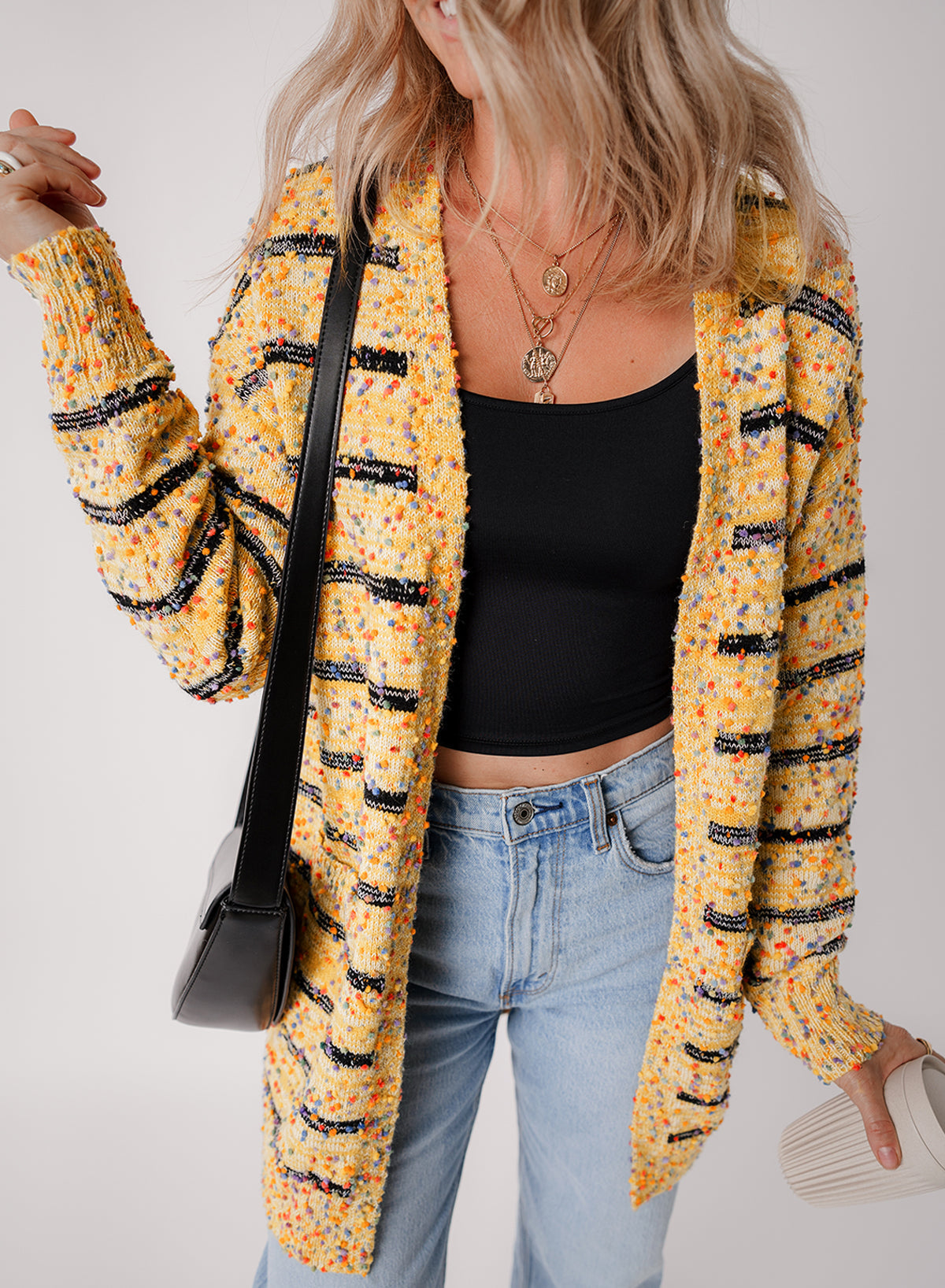 Cardigan long rayé en tricot a pompons ouvert sur le devant