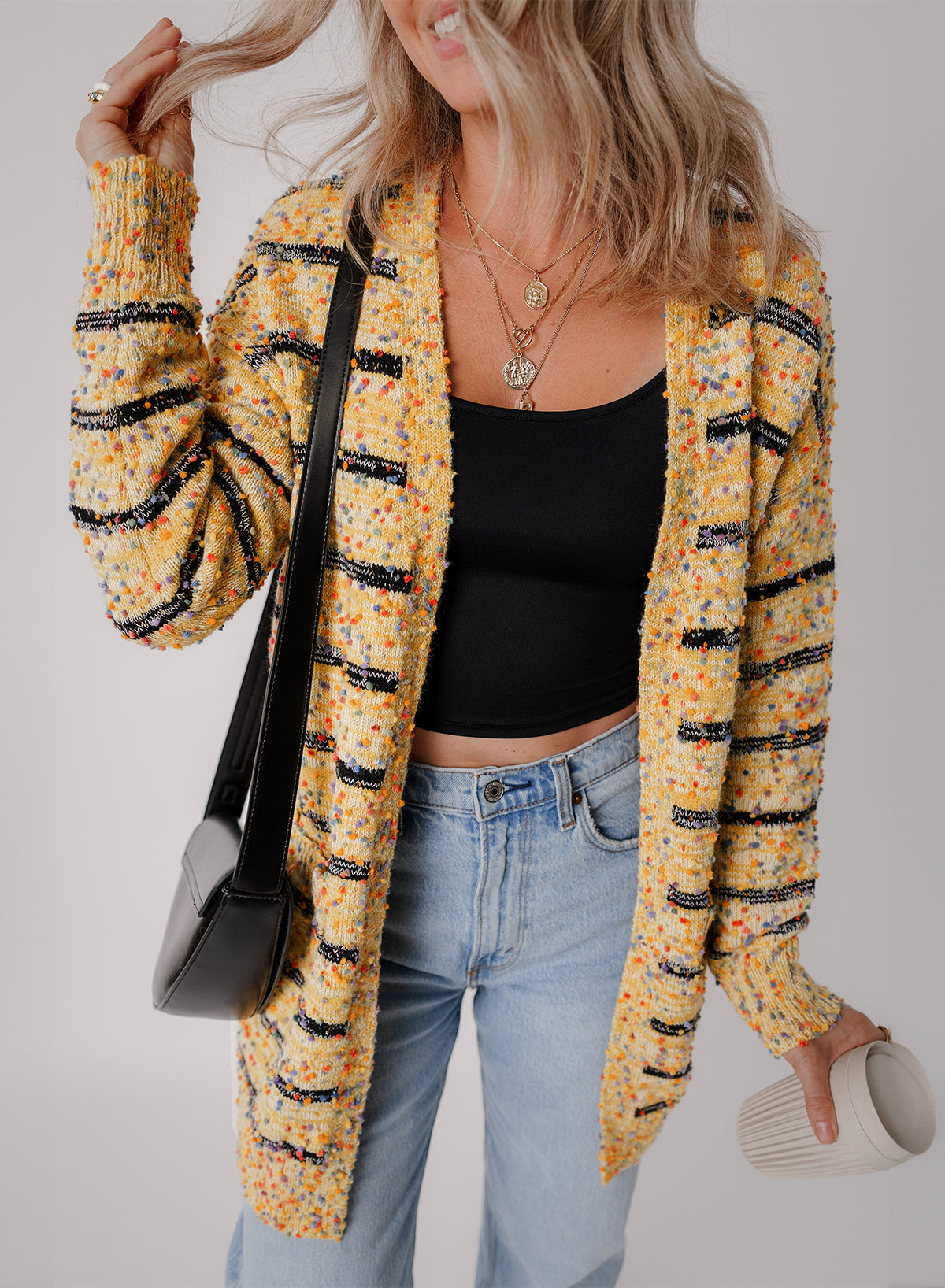Cardigan long rayé en tricot a pompons ouvert sur le devant