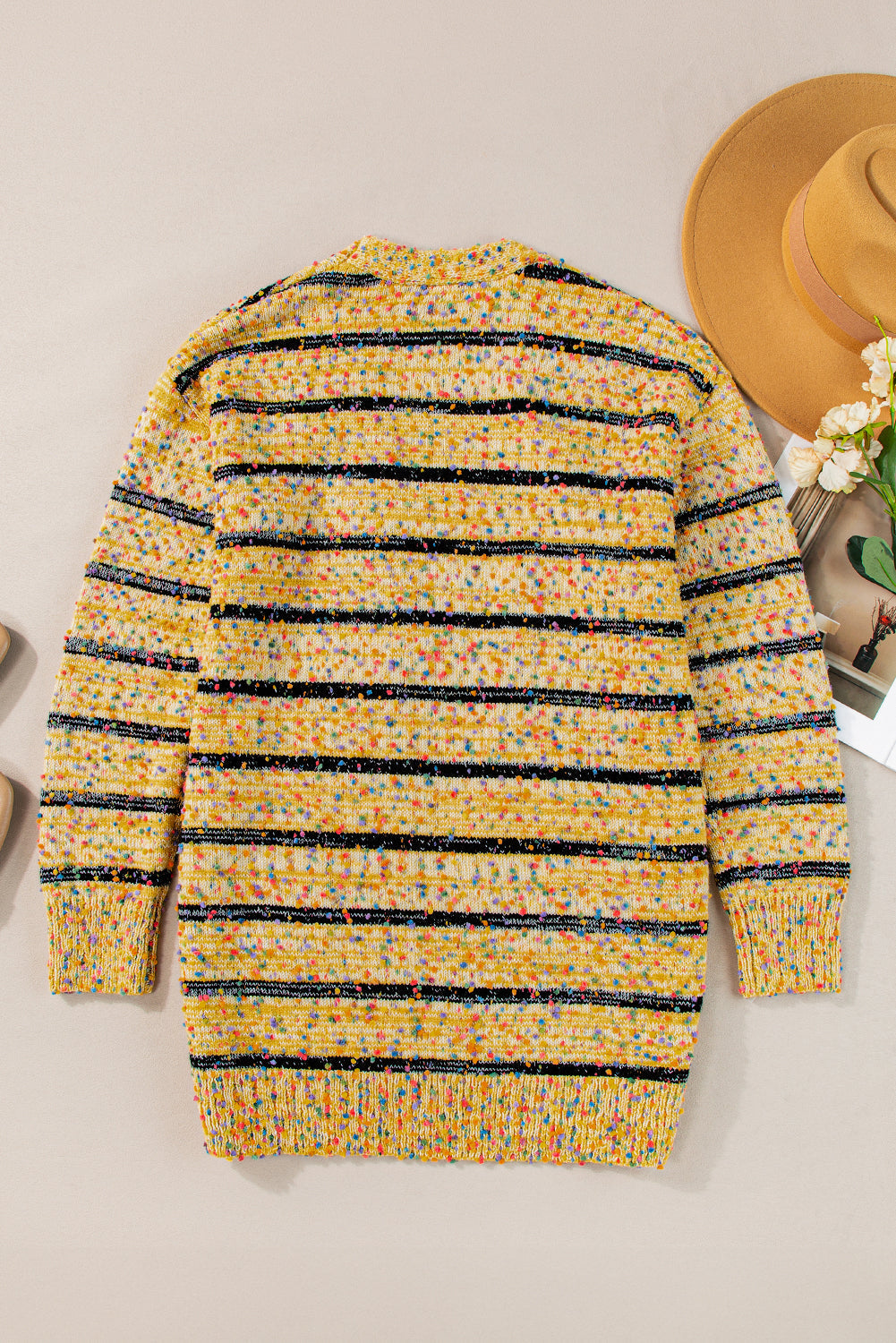 Cardigan long rayé en tricot a pompons ouvert sur le devant