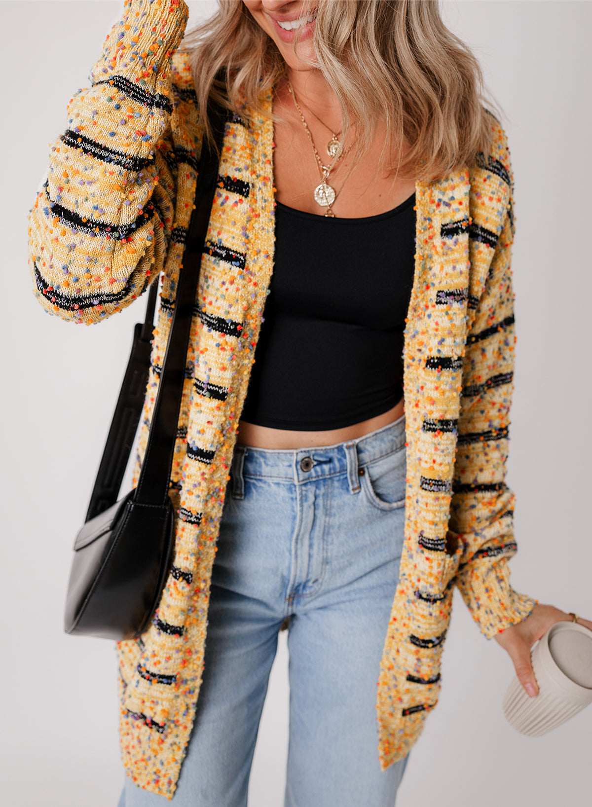 Cardigan long rayé en tricot a pompons ouvert sur le devant
