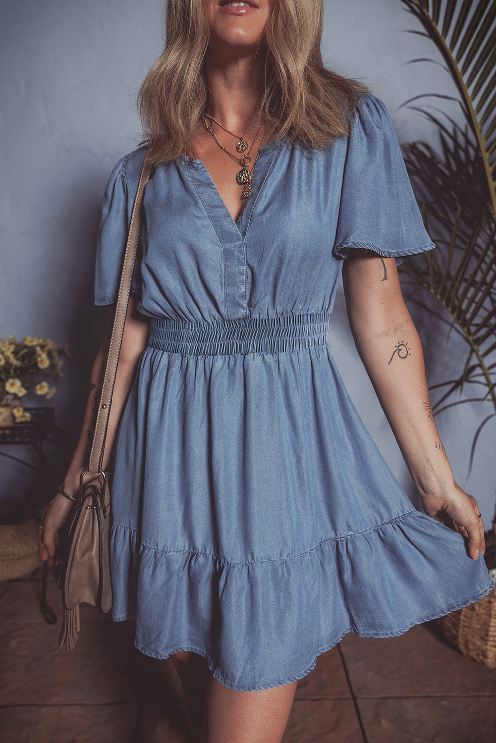 Mini-robe en jean taille haute à volants et col en V