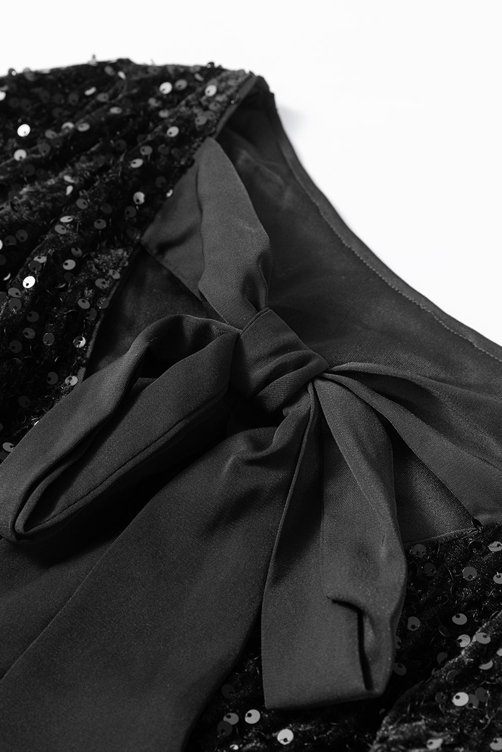 Mini-robe a paillettes et manches longues avec nœud découpé dans le dos