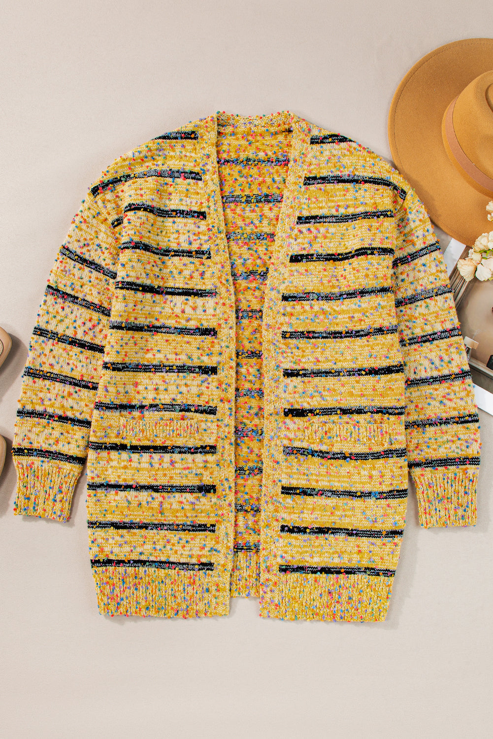 Cardigan long rayé en tricot a pompons ouvert sur le devant