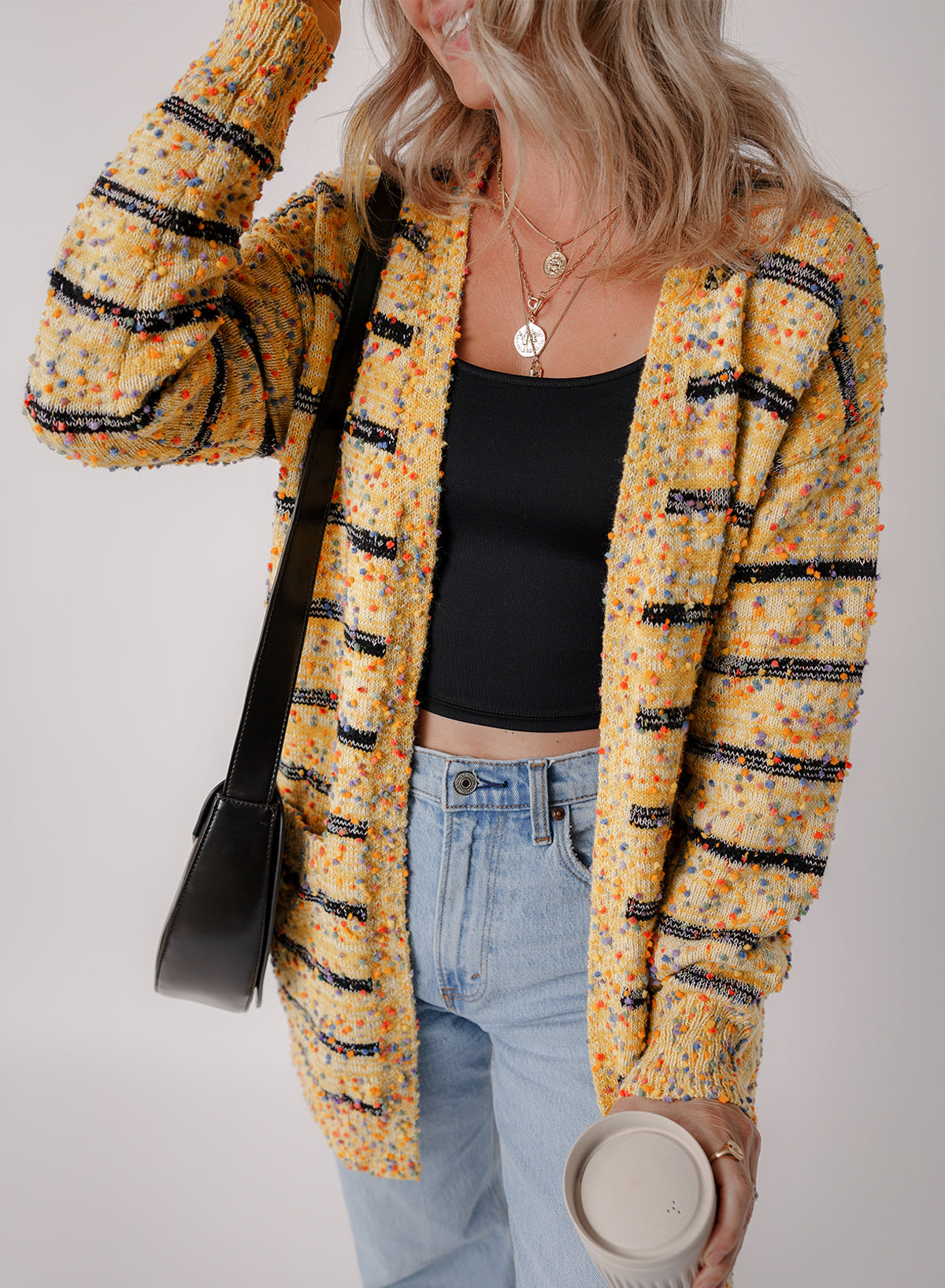 Cardigan long rayé en tricot a pompons ouvert sur le devant