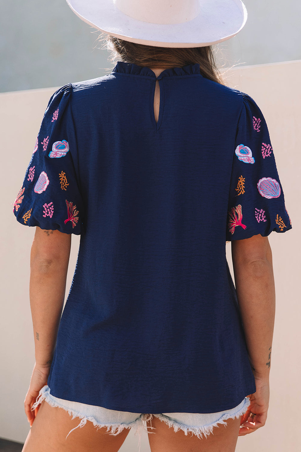Chemisier à manches bouffantes et col à volants avec broderie corail et coquillages