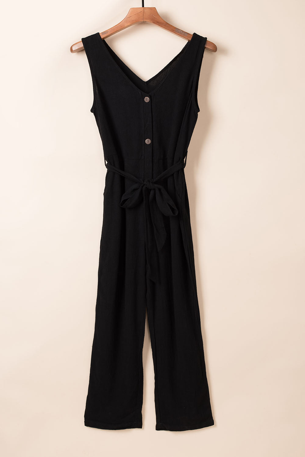 Combinaison noire ceinturée avec boutons et col en V avec poches