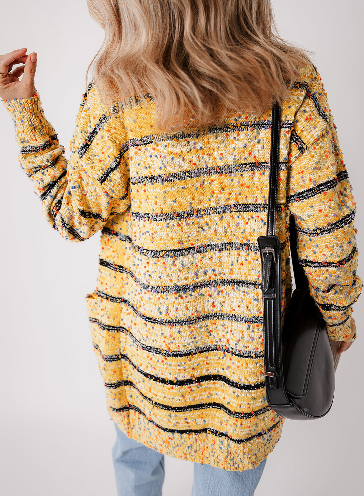Cardigan long rayé en tricot a pompons ouvert sur le devant