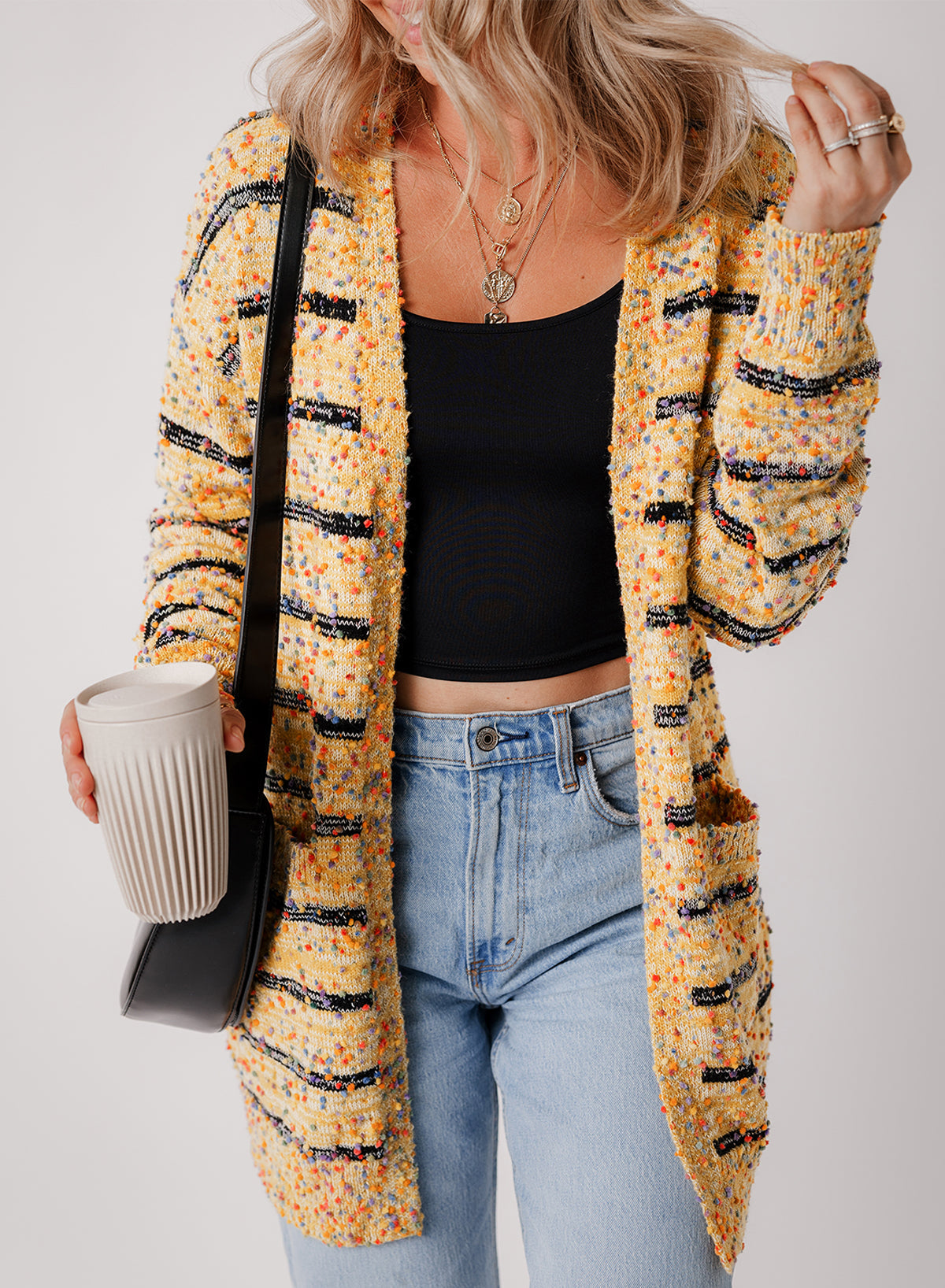 Cardigan long rayé en tricot a pompons ouvert sur le devant