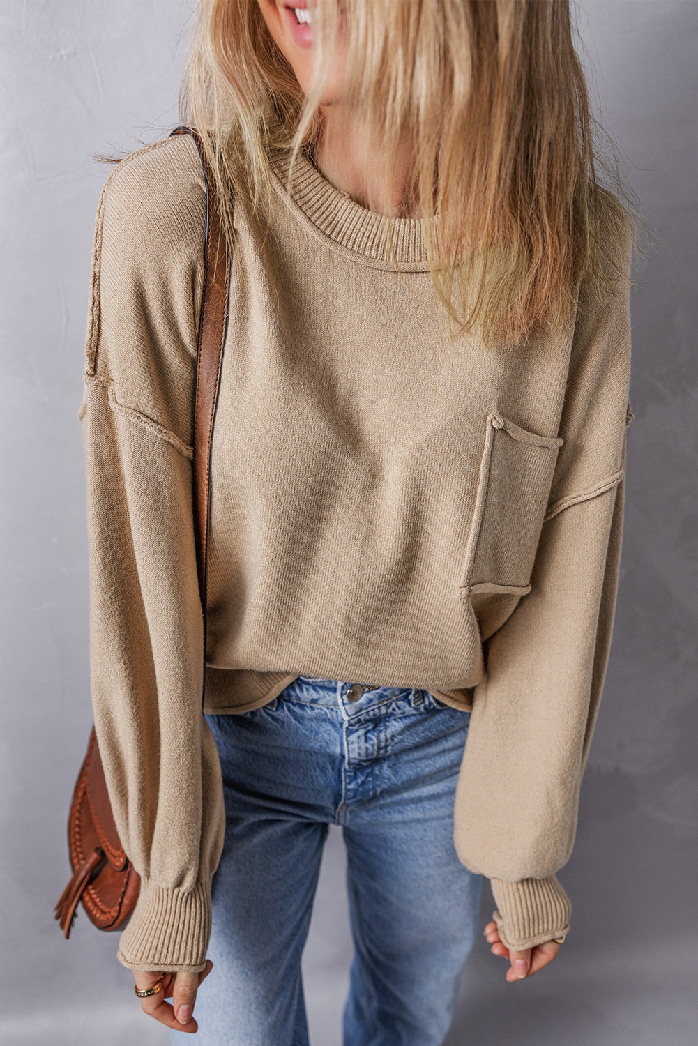 Pull ample a bords bruts et poche plaquée, coutures apparentes