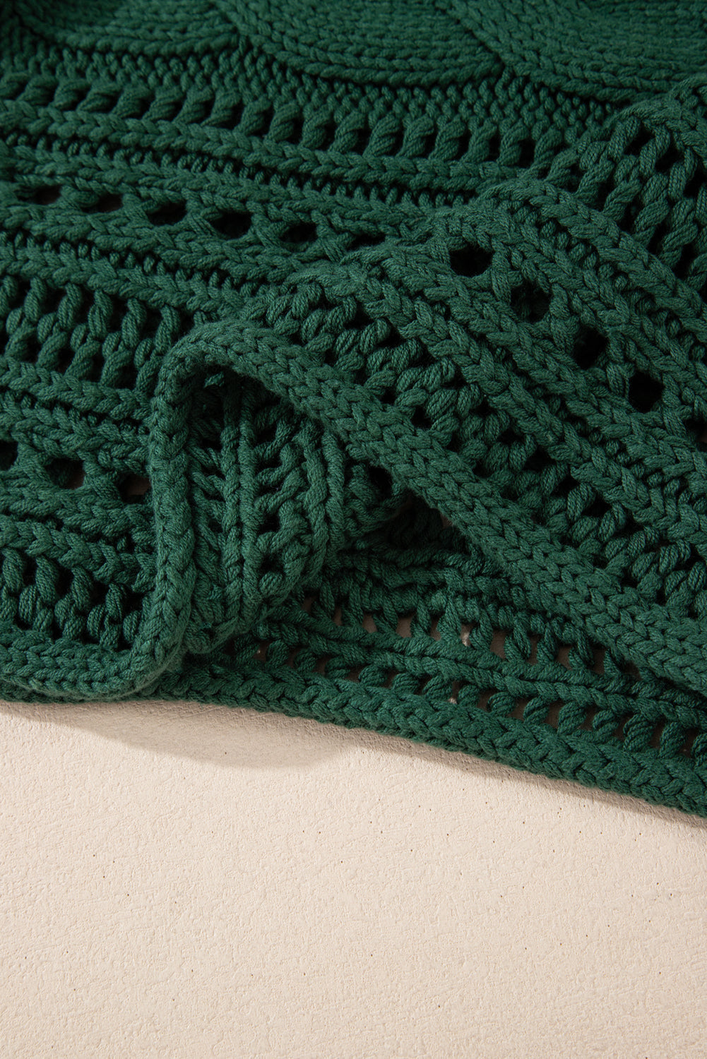 Pull court en tricot torsadé ajouré