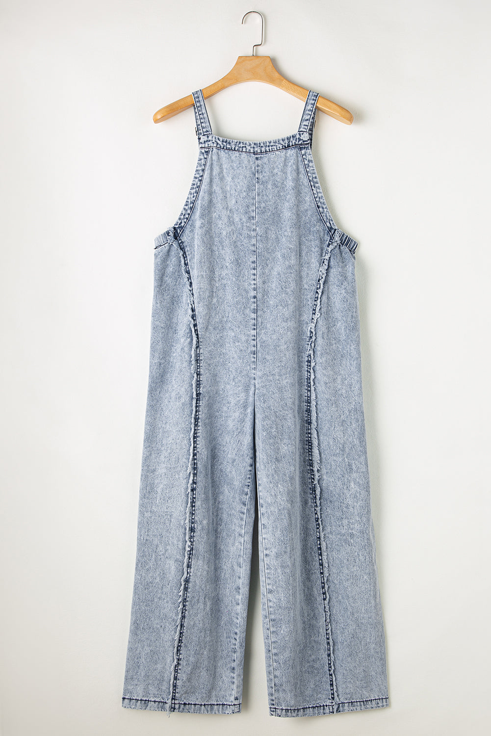 Salopette en denim à jambe large et effilochée délavé clair coutures apparentes