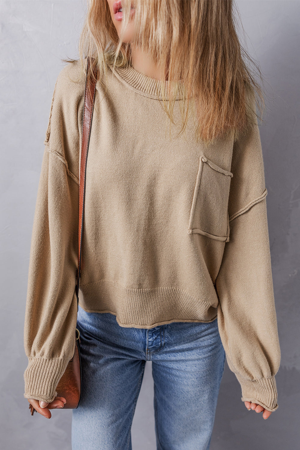 Pull ample a bords bruts et poche plaquée, coutures apparentes